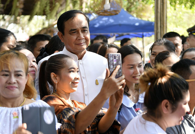After planting the sacred bodhi tree, Gen. Prayuth takes a selfie with a fan.