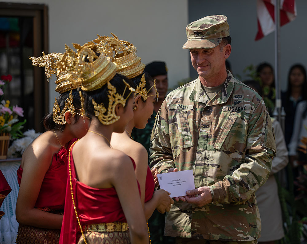 U.S. Army Col. Jerry Hall, US Army Pacific, hands an envelope to school children at a dedication ceremony for a new building at the Banchaladrakang School on Wednesday. Photo: U.S. Army