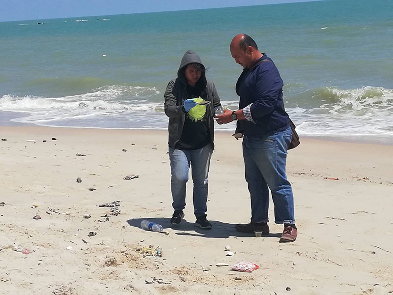 An official collects oil samples Monday at Samila Beach in Songkhla province.