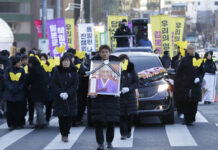 Woman Enslaved by Japan’s Military Mourned Near Protest Site A mourner with a portrait of the deceased Kim Bok-dong, a former South Korean sex slave, marches toward the Japanese Embassy during her funeral ceremony Friday in Seoul, South Korea. Photo: Ahn Young-joon / Associated Press