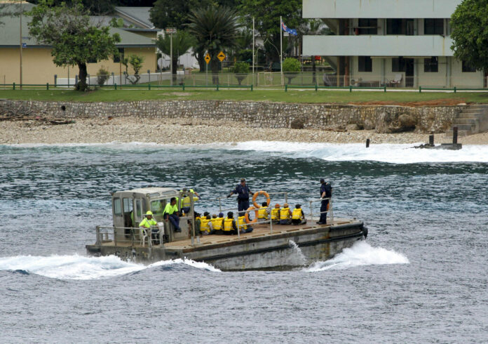A group of Vietnamese asylum seekers are taken by barge to a jetty in 2013 on Australia's Christmas Island. Photo: Associated Press