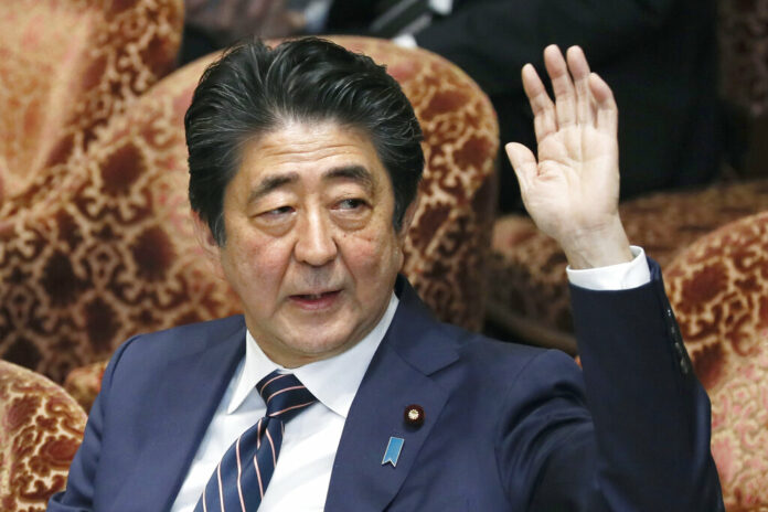 Japanese Prime Minister Shinzo Abe raises his hand during a parliamentary session at the Lower House in Tokyo on Monday. Photo: Kyodo News via Associated Press