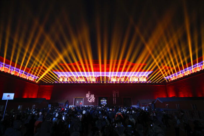 Visitors watch the Wumen Gate wall of the Forbidden City is illuminated during the Lantern Festival in Beijing, Tuesday, Feb. 19, 2019. Photo: Andy Wong / Associated Press