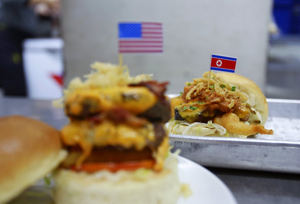 A "Durty Donald" and a "Kim Jong Yum" - Trump and Kim inspired burgers are freshly made Sunday in a restaurant in Hanoi, Vietnam. Photo: Hau Dinh / Associated Press