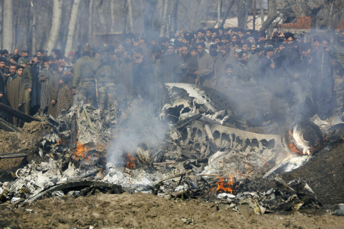 Kashmiri villagers gather near the wreckage of an Indian aircraft Wednesday after it crashed in Budgam area, outskirts of Srinagar, Indian controlled Kashmir. Photo: Mukhtar Khan / Associated Press