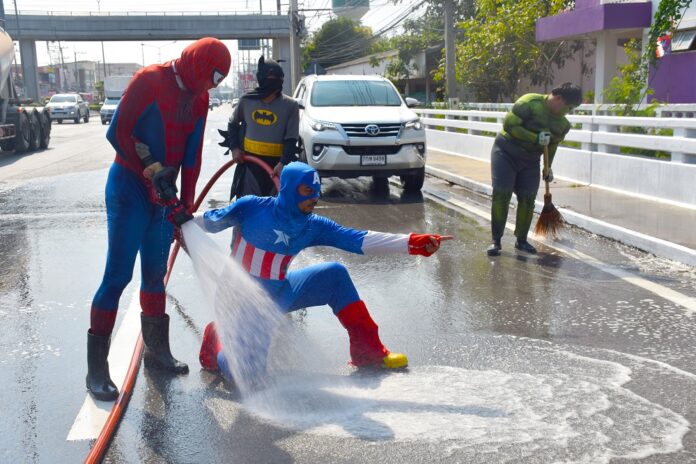 From left to right: Spiderman, Batman, Captain America and Hulk wash road surfaces on Monday