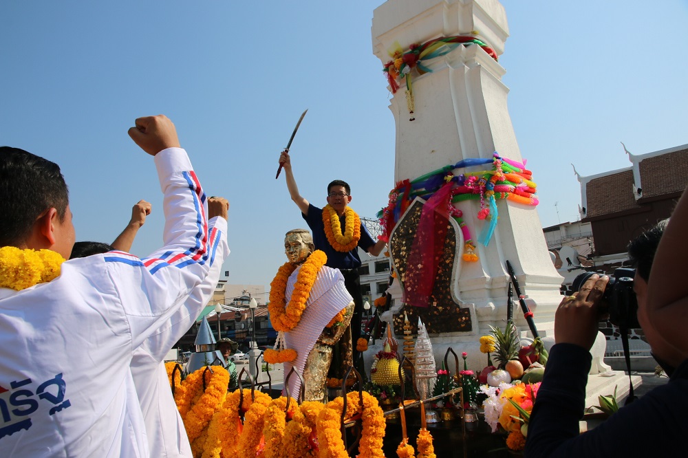 An MP candidate for Phalang Pracharat Party draws sword at a shrine in Korat on Thursday for good luck.