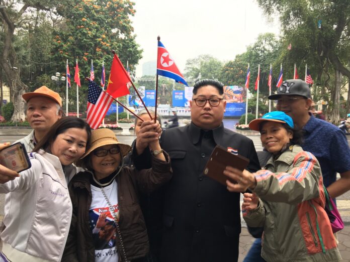 Kim Jong Un impersonator Uthen Lueangsaengthong, third from right, takes selfies with passersby Wednesday in Hanoi, Vietnam.