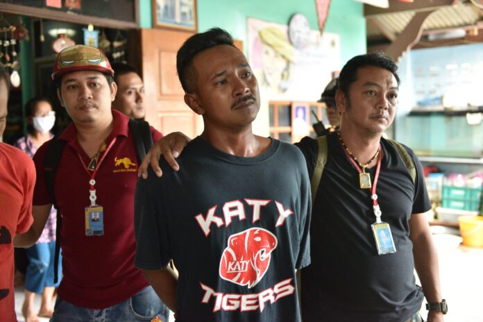 Wallop Nutfaeng, the lead suspect in the attack on a Bangkok temple school, cries Tuesday as police raid his home.