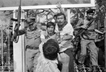 Opinion: Anti-Communist Song Belongs in Thailand’s Past, Period A man raises his fist to punch a captured student activist during a police crackdown at Thammasat University on Oct. 6, 1976. Witnesses said 'Scum of the Earth' was played during the massacre.