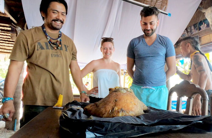 Boonyos Tala-upara, left, smiles Wednesday at a lump of what could be ambergris on Koh Samui.