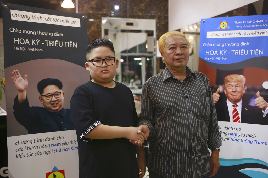 Le Phuc Hai, 66 and To Gia Huy, 9, pose for a photo after having Trump and Kim haircuts Tuesday in Hanoi. Photo: Hau Dinh / Associated Press