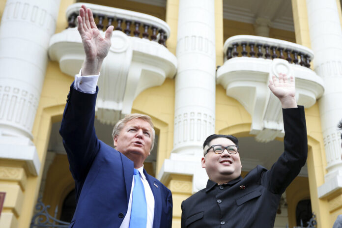 U.S. President Donald Trump impersonator Russell White, at left, and Kim Jong-un impersonator Howard X pose for photos Friday outside the Opera House in Hanoi. Photo: Minh Hoang / Associated Press