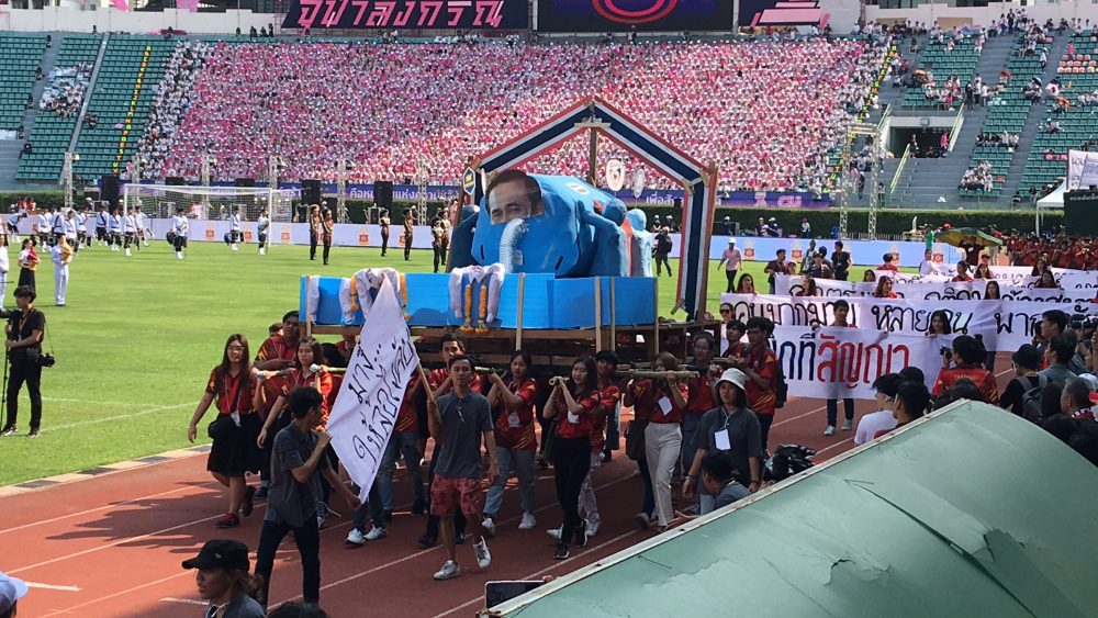 A float carried by students shows junta chairman Prayuth Chan-ocha literally leeching support from political parties including the Democrat and Bhum Jai Thai parties at Saturday's CU-TU game.