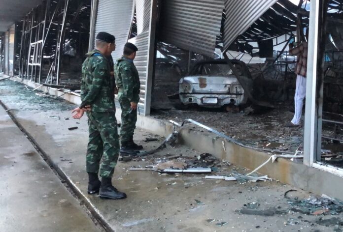 Security officers inspect the site of the fire.