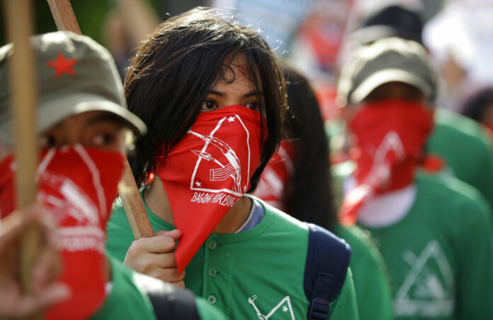 Philippines Communist Rebels In this March 25, 2019, file photo, masked members of the outlawed National Democratic Front of the Philippines, the umbrella organization of the Philippine communist movement, listen during a demonstration in Manila, Philippines. Photo: Aaron Favila / Associated Press