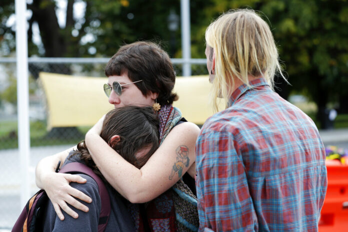 Mourners react as they pay their respects at a makeshift memorial outside Christchurch hospital in Christchurch, New Zealand, Saturday, March 16, 2019. Photo: Vincent Thian / Associated Press
