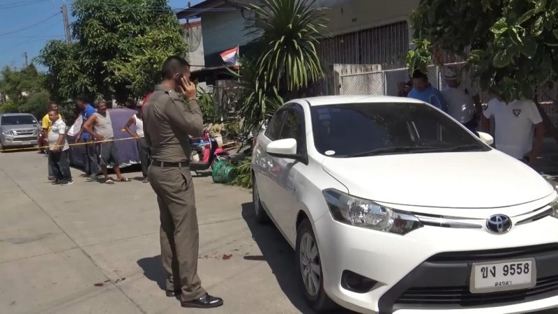 A police officers stands near a car Tuesday in Songkhla city, where former police Capt. Watcharin Benjatossawas was shot to death.