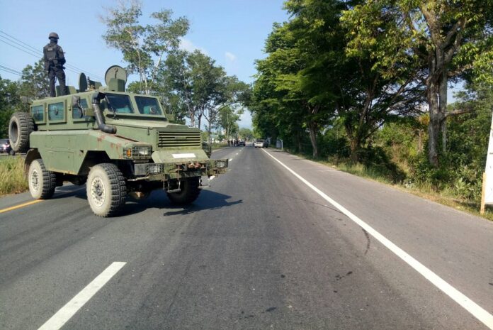 Armed soldiers guard a road in Narathiwat province on Monday.