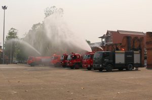 Not Songkran: Trucks spray water onto the ground Tuesday before Chiang Mai city’s most visible landmark, the Thapae Gate, in a bid to convince the public action is being taken.