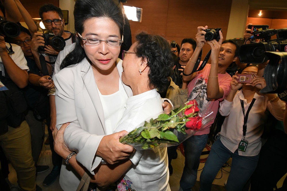Pheu Thai PM candidate Sudarat Keyuraphan hugs a supporter at her party headquarters, minutes after several pollsters predict her party as the winner.