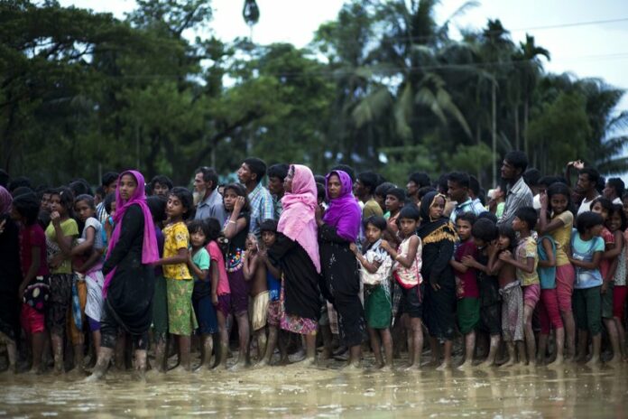 Rohingya Muslims stand in a queue to receive food being distributed near Balukhali refugee camp in Cox's Bazar, Bangladesh, Tuesday, Sept. 19, 2017. Photo: Bernat Armangue / AP