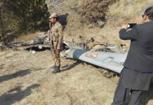 Pakistan Ready to Hand Over Indian Pilot Amid More Shelling A Pakistani soldier stands guard near the wreckage of an Indian plane shot down by the Pakistan military on Wednesday, in Hurran, near the Line of Control in Pakistani Kashmir. Photo: Abdul Razzaq / Associated Press