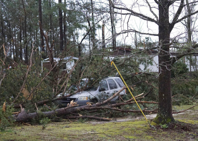 A vehicle is caught under downed trees along Lee Road 11 in Beauregard, Ala. on Sunday after a powerful storm system passed through the area. Photo: Kara Coleman Fields / Opelika-Auburn News via AP