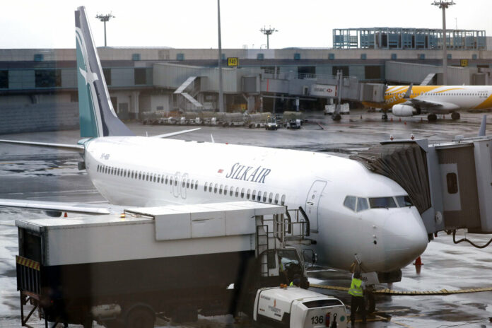 SilkAir's new Boeing 737 Max 8 aircraft is seen through a viewing gallery window in 2017 parked on the ramp of Singapore's Changi International Airport. Photo: Wong Maye-E / Associated Press