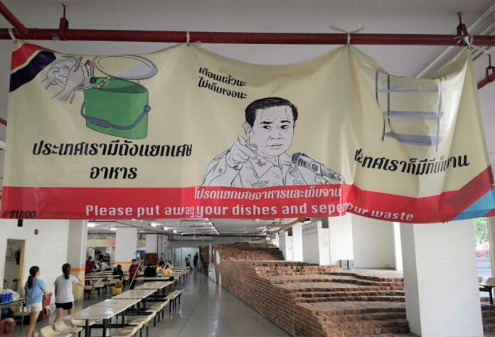 A poster with an image of junta leader Prayuth Chan-ocha telling Thammasat University students to put their dishes at proper places after eating at a canteen.