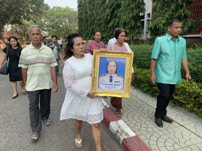 Laem Oun-on carries a portrait of her daughter Juthaporn Oun-on to hear the verdict on Thursday in Si Saket province.