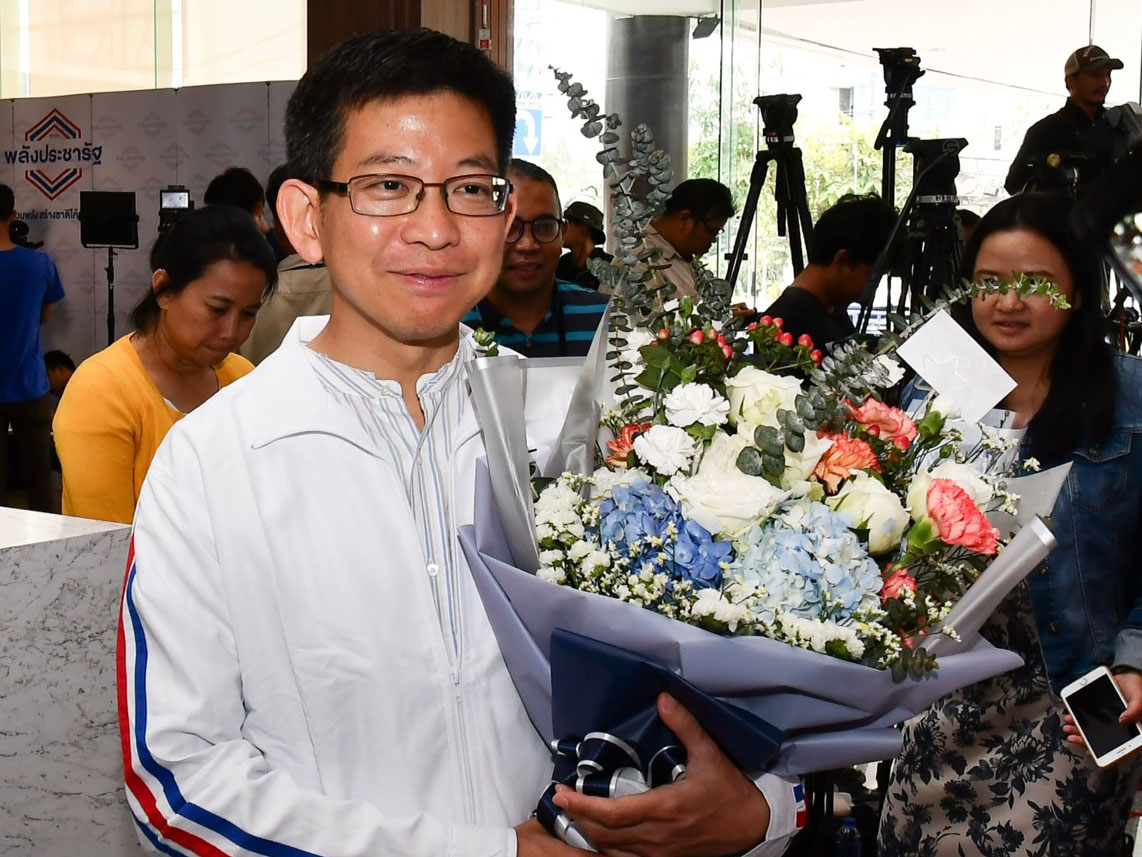 Kobsak Pootrakul holds a bouquet of hydrangeas, carnations and roses at the Phalang Pracharat headquarters on Monday.