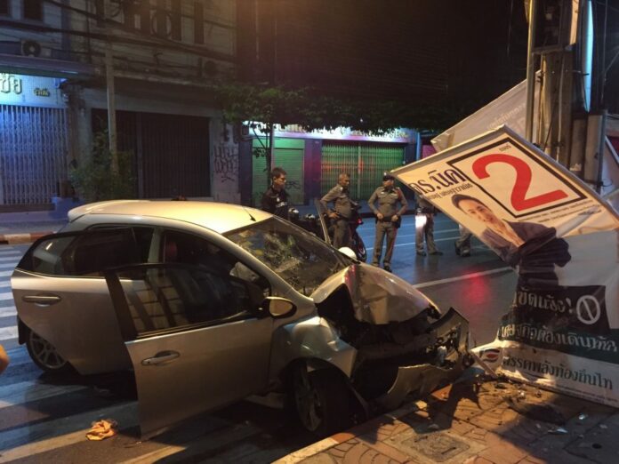 Police officers stand near the scene of a fatal car crash Thursday morning in Bangkok.