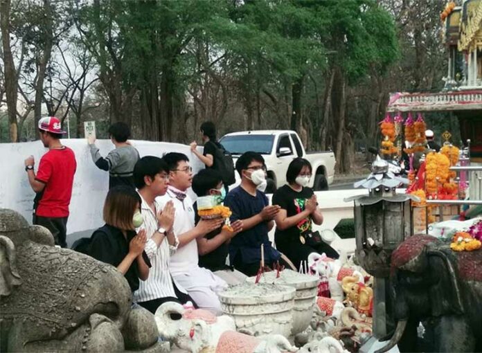 Chiang Mai University students offer face masks to the spirits in a mock ceremony held Tuesday as part of a protest calling attention to severe air pollution in the north. Photo: @Dopemexmyg_ / Twitter