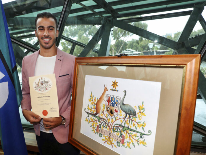 Hakeem al-Araiby, a former Bahraini international soccer player and refugee, displays his certificate after becoming an Australian citizen Tuesday, four weeks after escaping extradition to his homeland during a much-publicized detention in a Bangkok prison, in Melbourne. Photo: David Crosling / AAP Image via AP