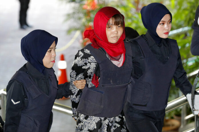 Vietnamese Doan Thi Huong, at center, is escorted by police into the Shah Alam High Court on Thursday in Shah Alam, Malaysia. Photo: Vincent Thian / Associated Press