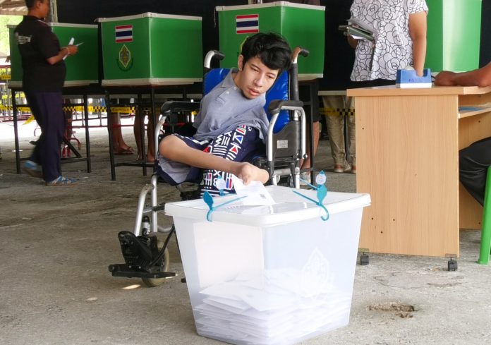 Watanyu Boonyok, a disabled voter, casted his ballot with his toes Sunday morning in Trat province.