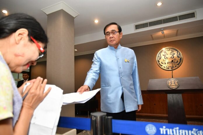 Gen. Prayuth Chan-ocha hands back list of questions to a reporter March 26, 2019, at Government House