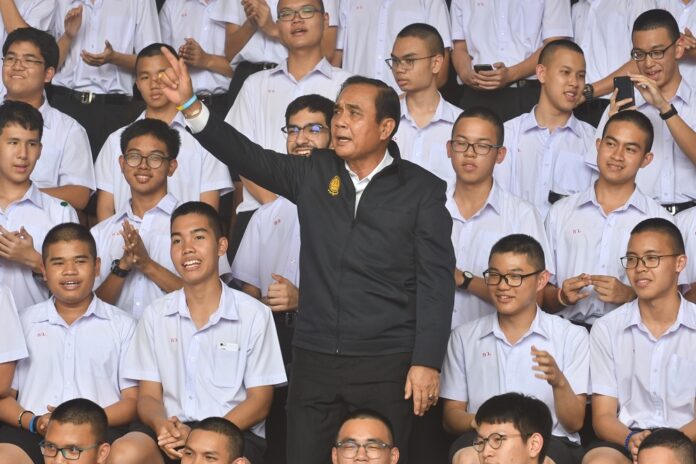 Junta chairman Prayuth Chan-ocha sings along with students at a school in Rayong province on Feb. 27, 2019.