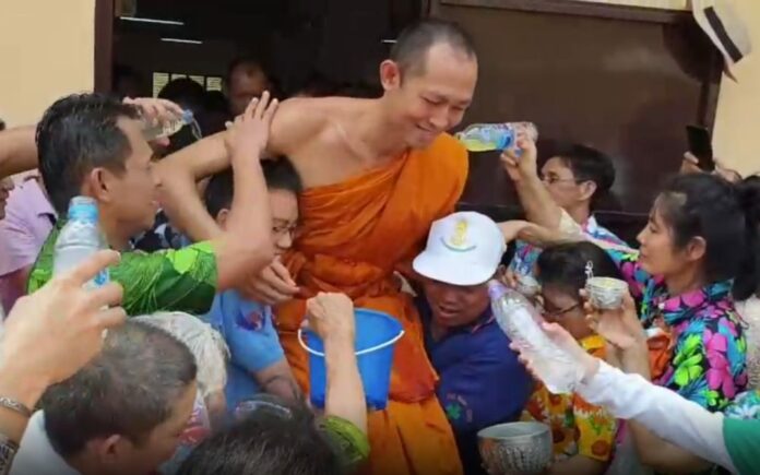 Worshipers pour water mixed with jasmines on monks in Kanchanaburi province.