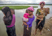 UN Rights Agency Condemns Combat in Myanmar’s Rakhine State In this Oct. 18, 2017, file photo, Rohingya Muslim women, who crossed over from Myanmar into Bangladesh, stand holding their sick children after Bangladesh border guard soldiers refused to let them journey towards a hospital and turned them back towards the zero line border in Palong Khali, Bangladesh. Photo: Dar Yasin / Associated Press