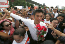 Gov’t Says Trying Thanathorn in Military Court is Fair Thailand's Future Forward Party leader Thanathorn Juangroongruangkit is mobbed by his supporters Saturday upon arrival at a police station in Bangkok. Photo: Sakchai Lalit / Associated Press
