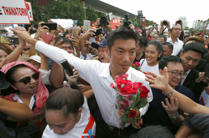 Thailand's Future Forward Party leader Thanathorn Juangroongruangkit is mobbed by his supporters Saturday upon arrival at a police station in Bangkok. Photo: Sakchai Lalit / Associated Press