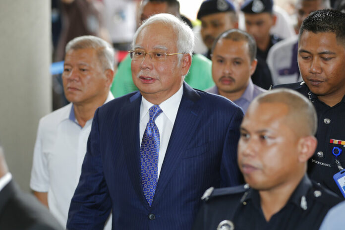 Former Malaysian Prime Minister Najib Razak, center, walks into a courtroom Wednesday at Kuala Lumpur High Court in Kuala Lumpur, Malaysia. Photo: Vincent Thian / Associated Press