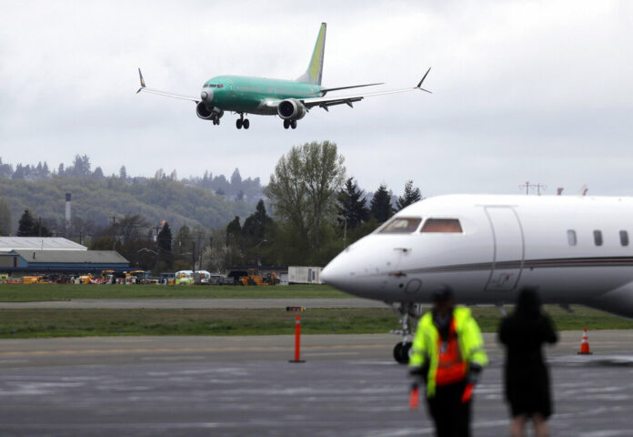 A Boeing 737 MAX 8 airplane being built for India-based Jet Airways, top, lands following a test flight, Wednesday, April 10, 2019, at Boeing Field in Seattle. Photo: Ted S. Warren / Associated Press