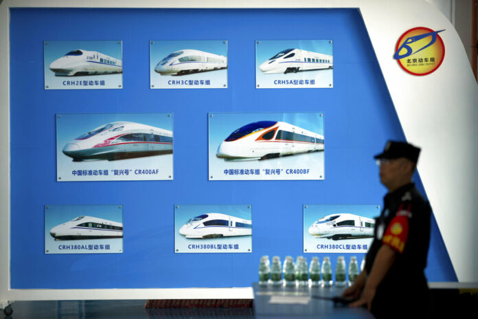 In this Aug. 30, 2018, file photo, a security official stands near a display showing different models of Chinese trains at a maintenance yard during a media tour ahead of the 2018 Forum on China-Africa Cooperation in Beijing. Photo: Mark Schiefelbein / Associated Press