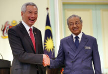 Singapore PM Defends Law Combating Fake Online News Malaysian Prime Minister Mahathir Mohamad, right, shakes hands with Singaporean Prime Minister Lee Hsien Loong Tuesday after a press conference in Putrajaya, Malaysia. Photo: Vincent Thian / Associated Press