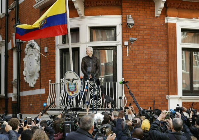 In this file photo dated Friday May 19, 2017, watched by the media WikiLeaks founder Julian Assange looks out from the balcony of the Ecuadorian embassy prior to speaking, in London. Photo: Matt Dunham / Associated Press