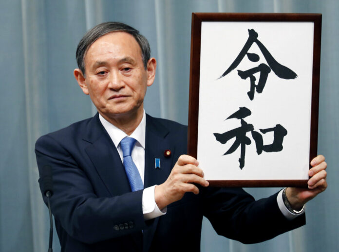 Japan’s Chief Cabinet Secretary Yoshihide Suga unveils the name of new era “Reiwa” at the prime minister’s office in Tokyo, Monday, April 1, 2019. Photo: Eugene Hoshiko / Associated Press