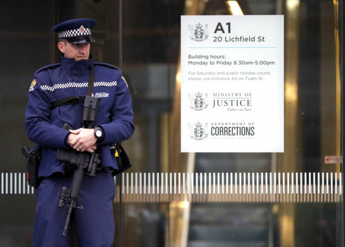 A armed police office stands guard Friday outside the entrance to the High Court in Christchurch, New Zealand. Photo: Mark Baker / Associated Press